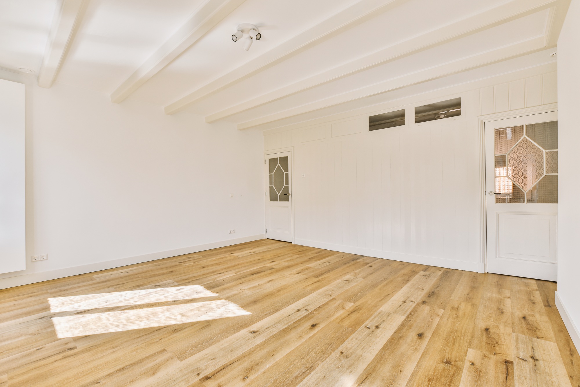a living room with white walls and a wood floor