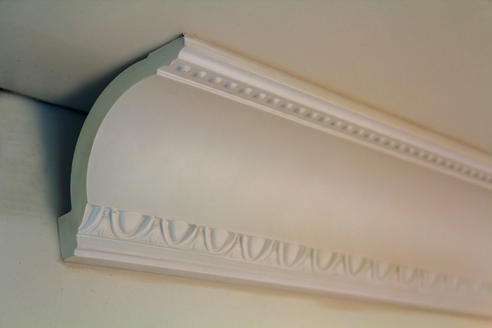 Close-up detail of decoration white molding connected with glue adhesive to wall